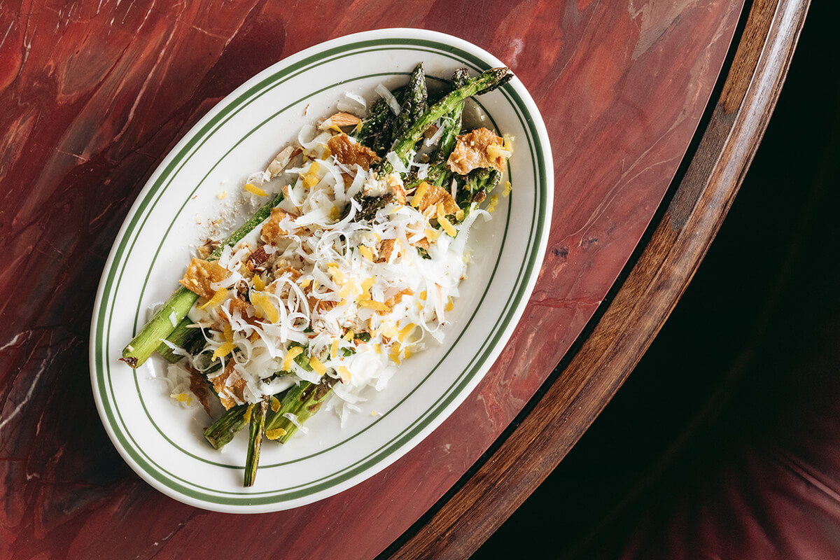 Woodfired asparagus, tarragon dressing, chicken skin, almond, pecorino. Photo: Josh Griggs